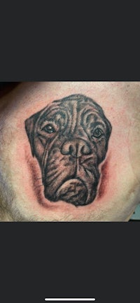 a black and grey tattoo of a dog's head